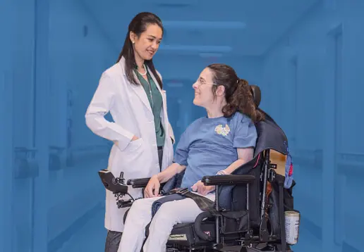 Cutout graphic highlighting young woman with spinal cord injury smiling and talking with doctor against blue background